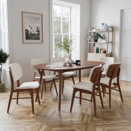 Dining room with wooden table and chairs on a wooden floor.