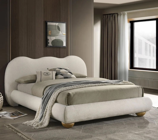 Modern bedroom with a beige upholstered bed and decorative pillows.