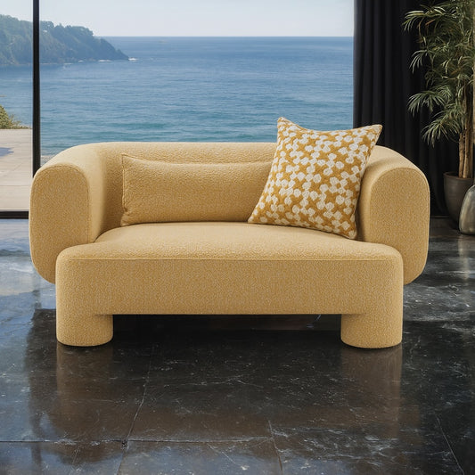 Yellow sofa with patterned cushions on a dark marble floor with ocean view