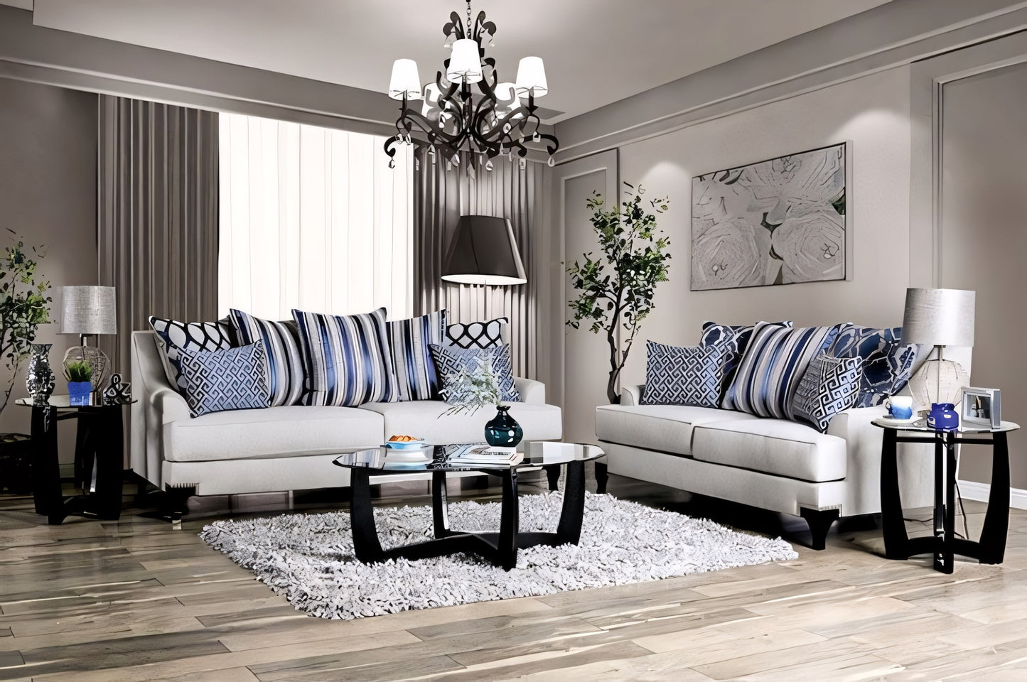 Modern living room with gray sofas, striped cushions, and a chandelier.