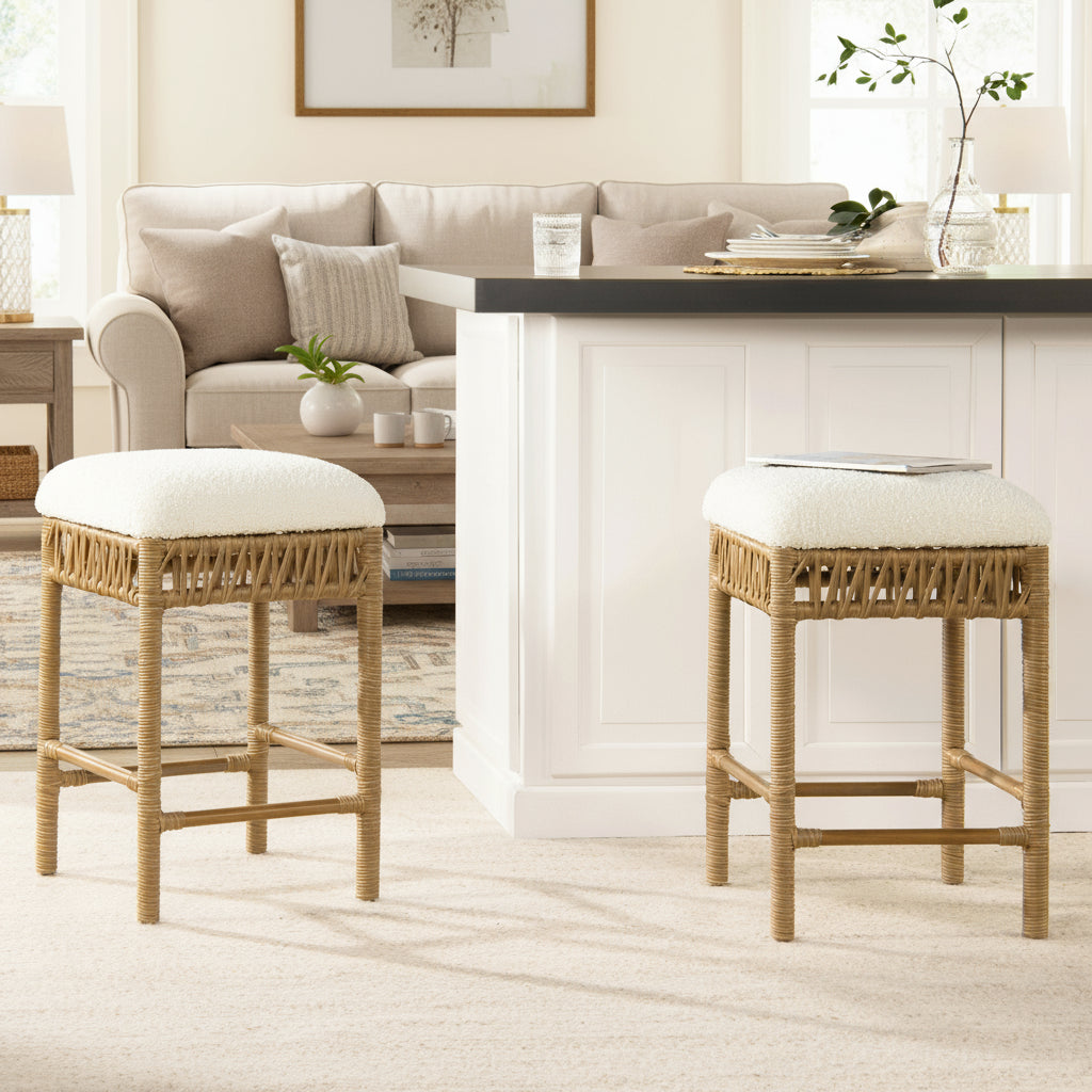 Two wicker bar stools with white cushions in a room with a table and window.