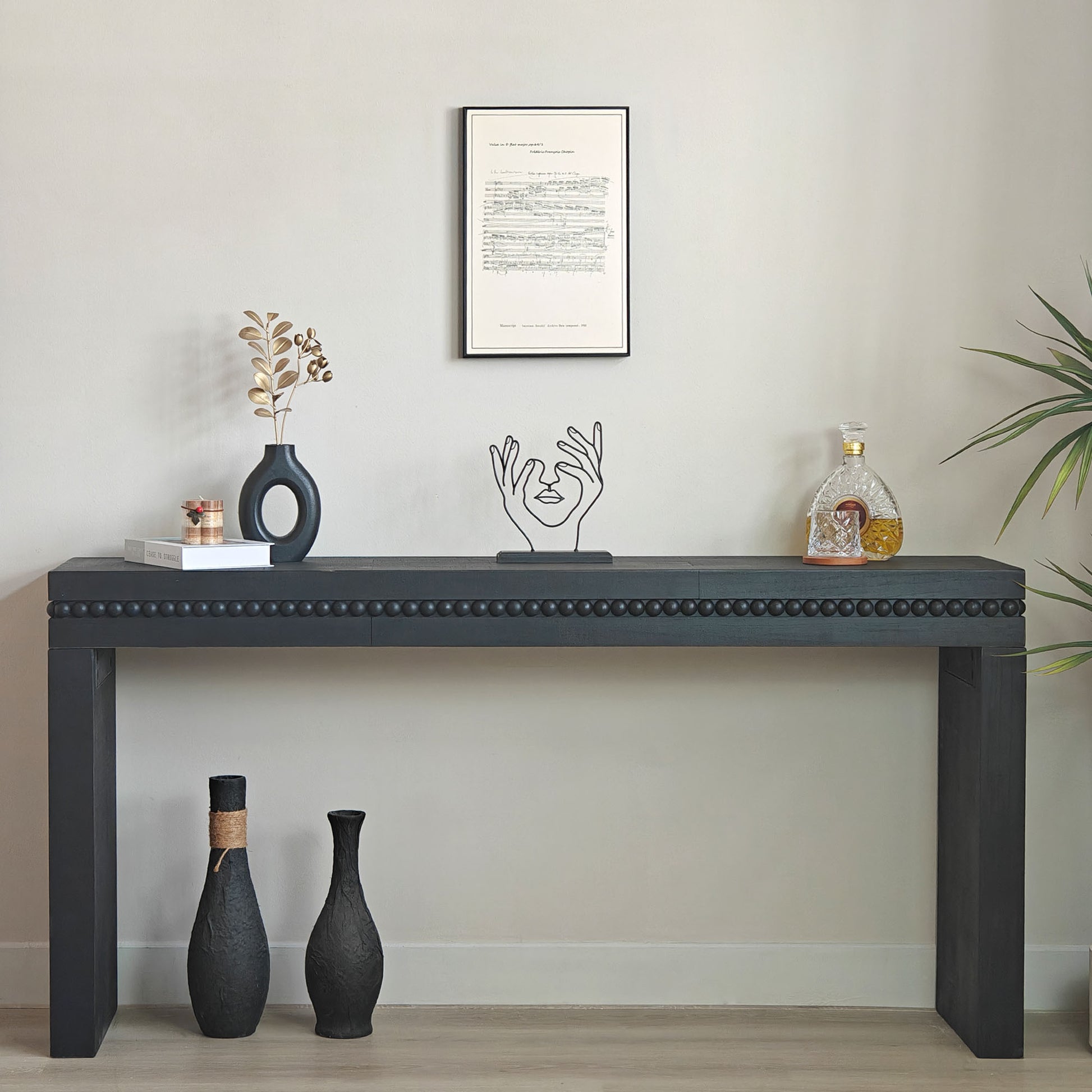 Black console table with decorative items against a plain wall