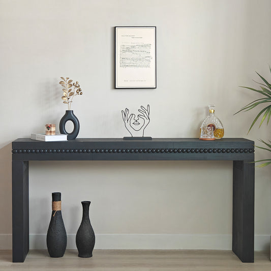 Black console table with decorative items against a plain wall