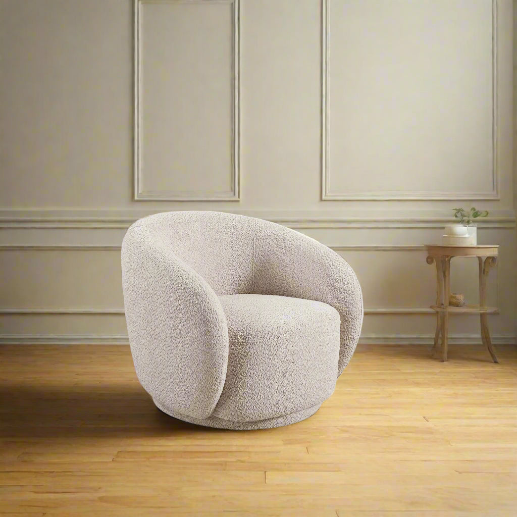 Beige armchair in a living room with a wooden cabinet and window in the background