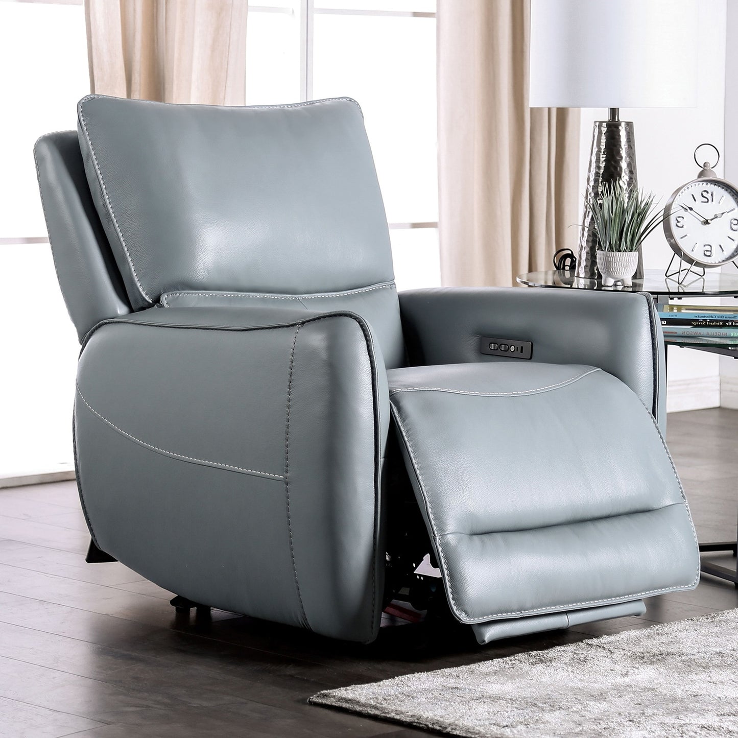 Gray recliner chair in a living room setting with a desk and clock in the background.
