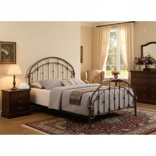 Metal bed frame with decorative headboard and footboard in a room with large windows.