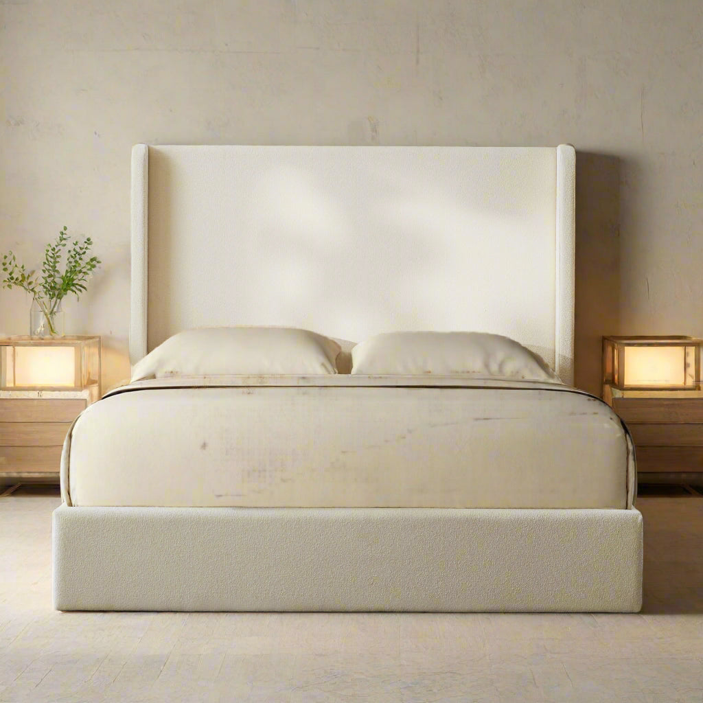 Ivory upholstered bed with a brown blanket in a bedroom setting.