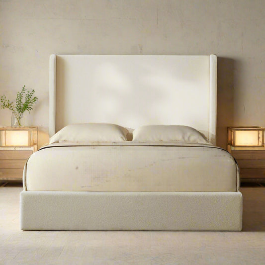 Ivory upholstered bed with a brown blanket in a bedroom setting.