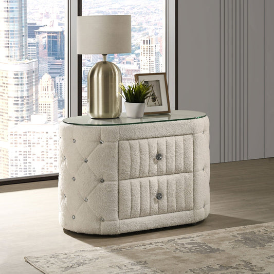 Modern nightstand with lamp and decor in a room with large windows showing a cityscape.