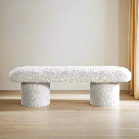 Modern white bench in a living room setting with a neutral color palette.