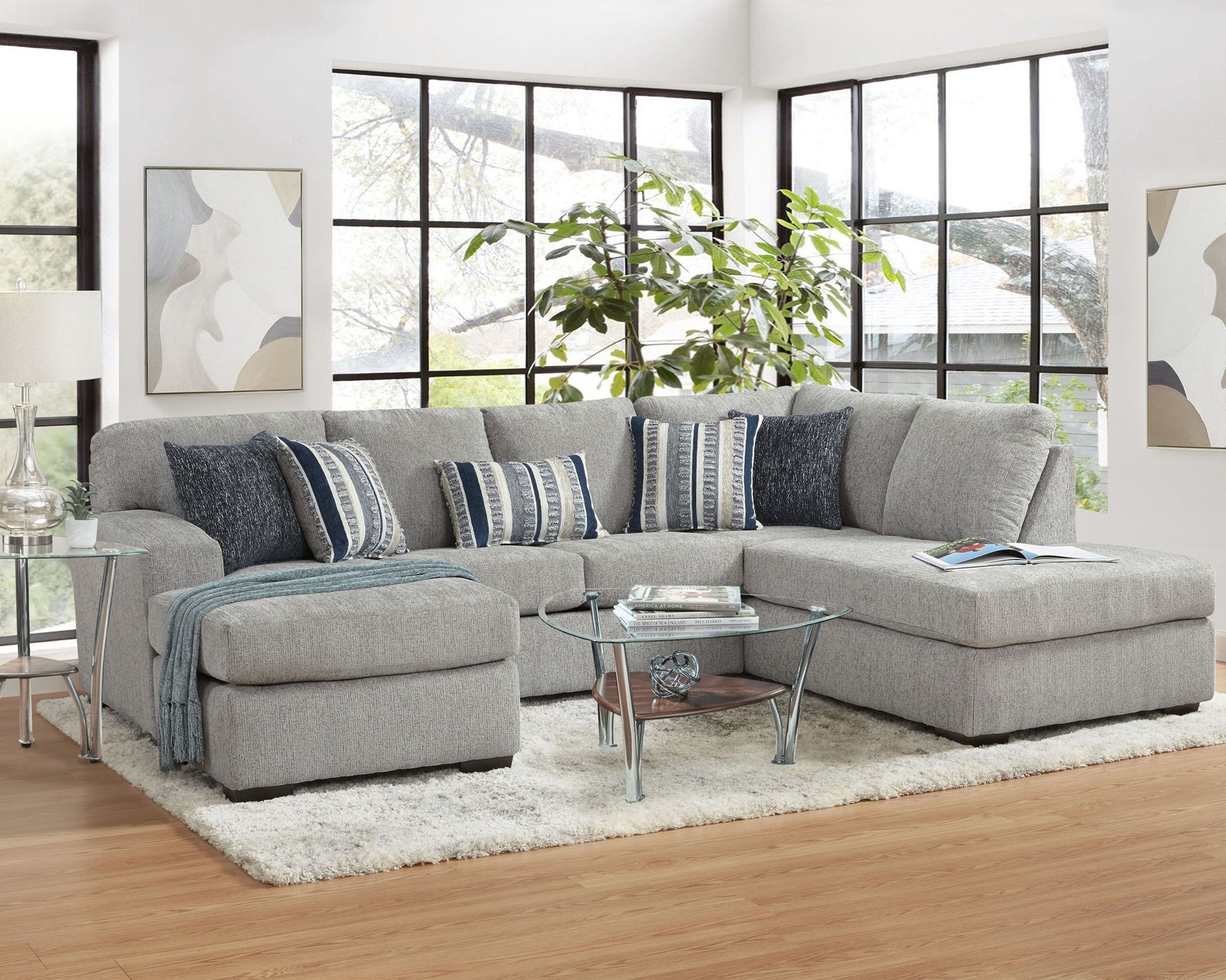 Gray sectional sofa in a living room with decorative pillows and a small table.