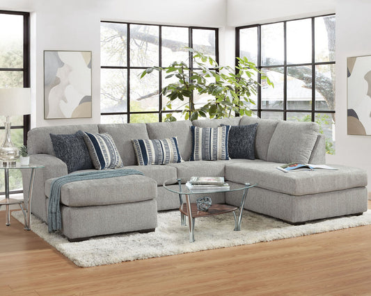 Gray sectional sofa in a living room with decorative pillows and a small table.