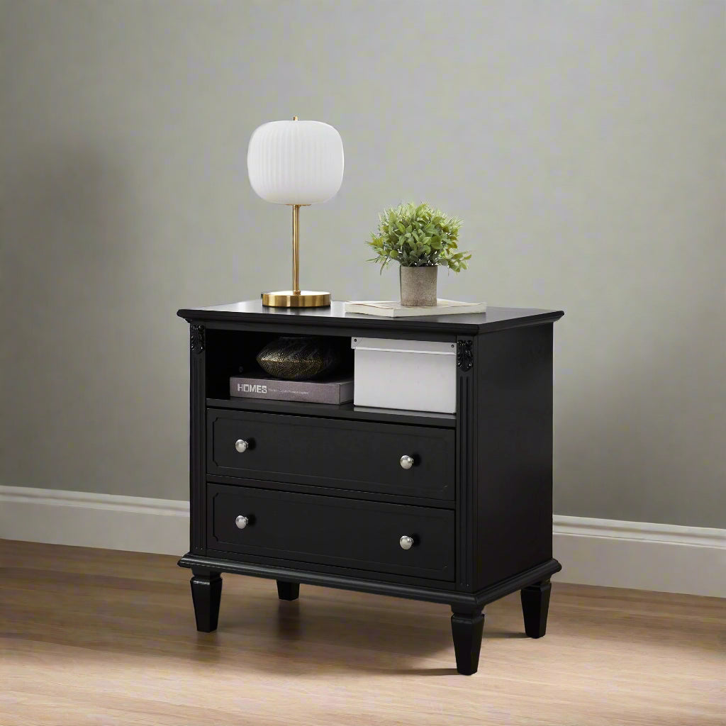 A black 2-drawer farmhouse nightstand with USB ports and a plant on top, placed in a well-lit living room setting.