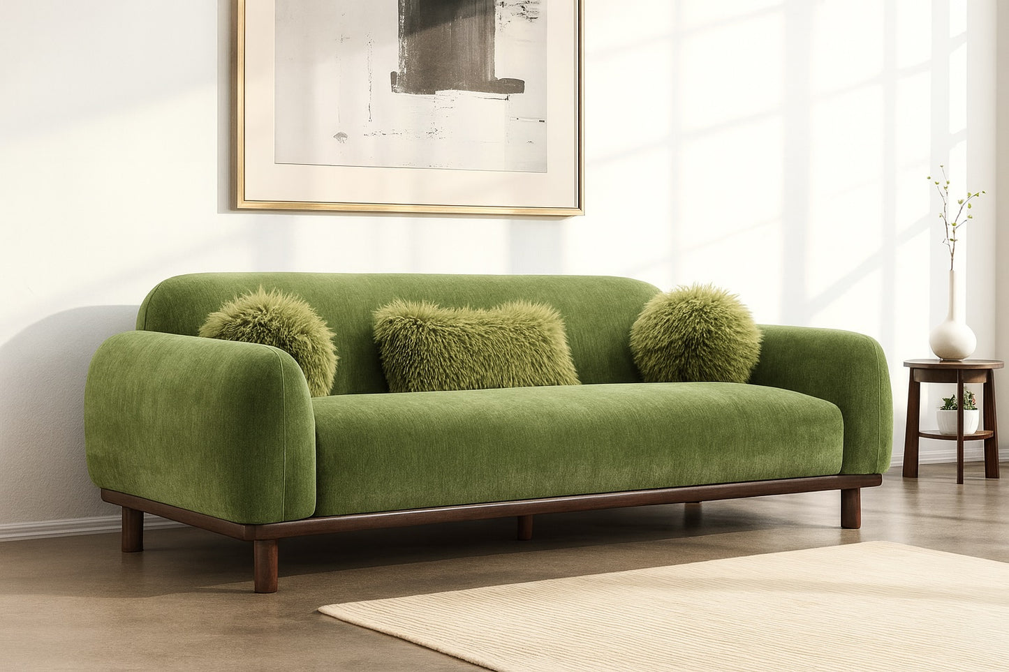 Green sofa with fluffy cushions in a room with a painting and a small table.