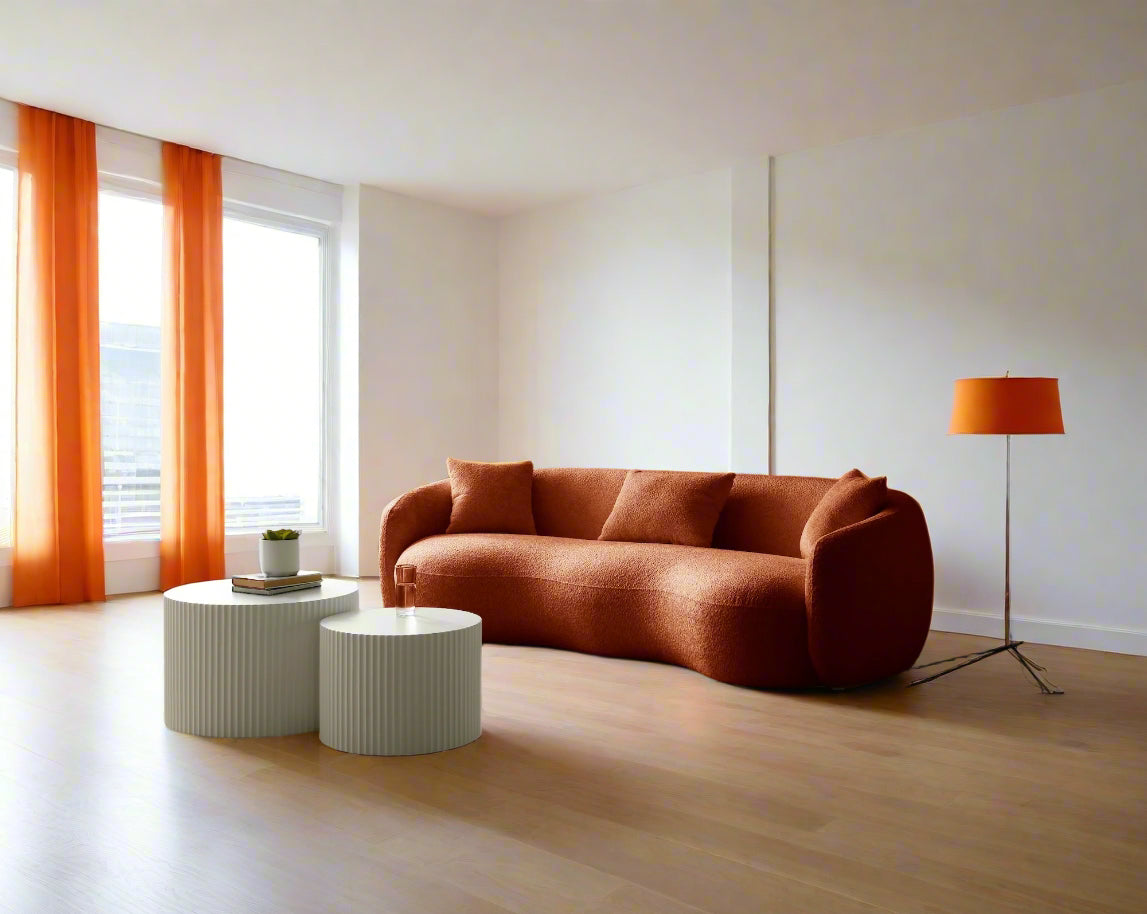 Modern living room with a orange sofa, white coffee table, and floor lamp.