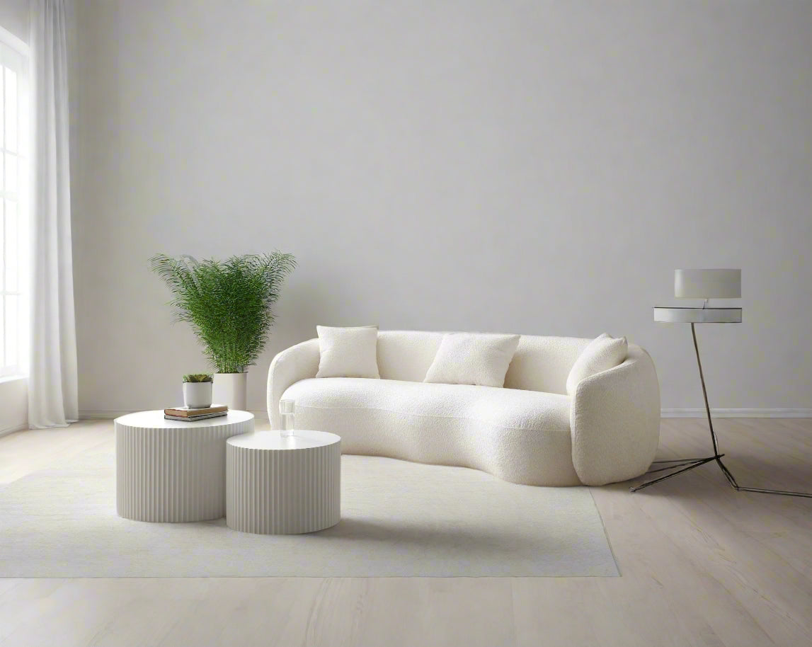 Modern living room with a white sofa, coffee table, and floor lamp.