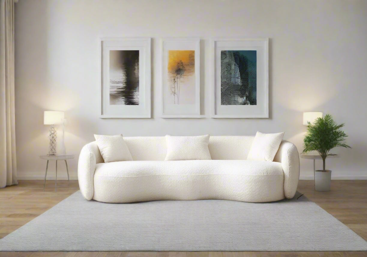 Modern living room with a white sofa, coffee table, and decorative items.