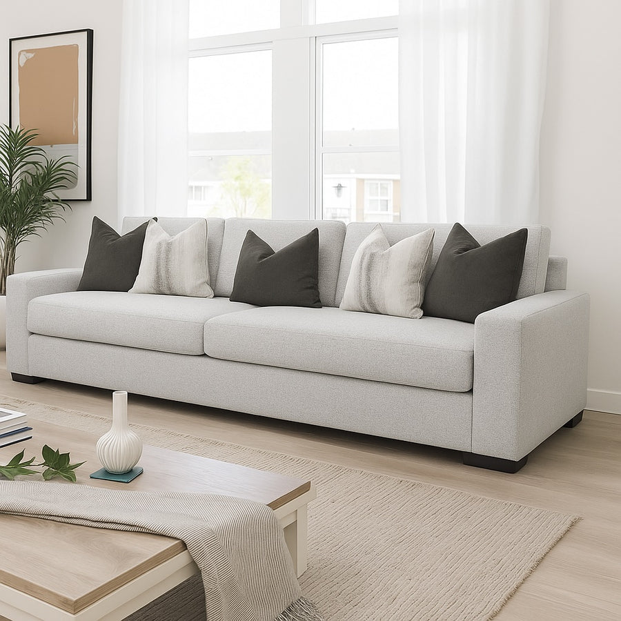 Light gray sofa with patterned cushions in a bright living room.