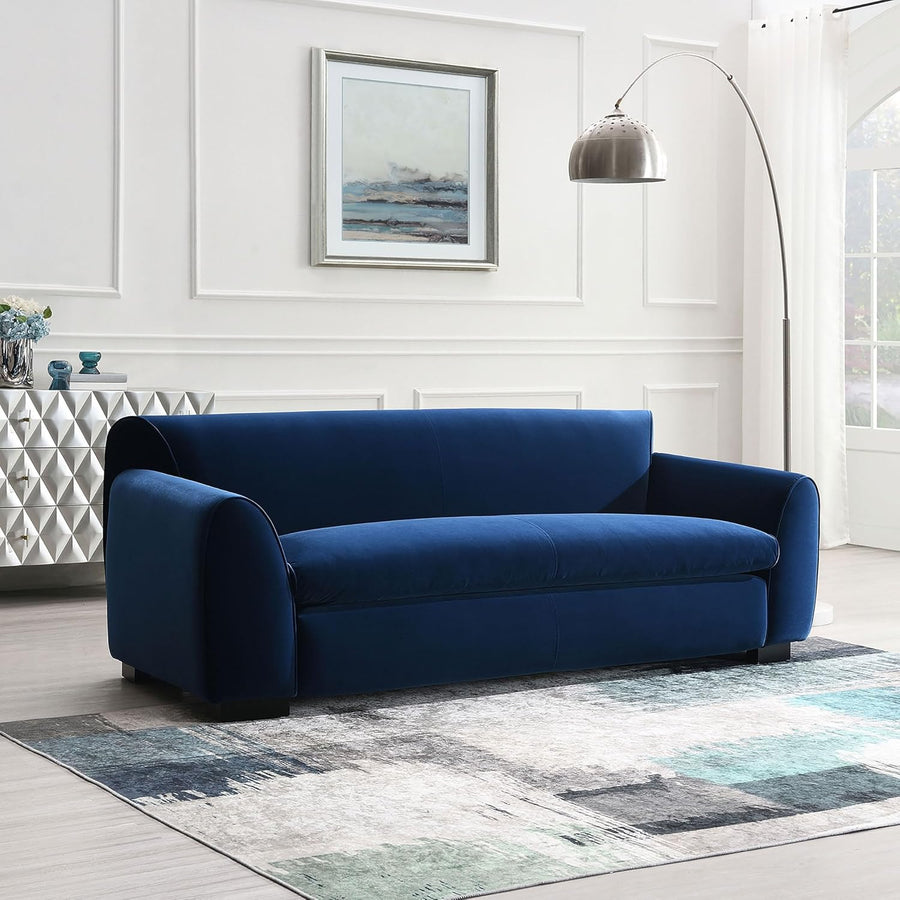 Blue sofa in a modern living room with a rug and wall art.