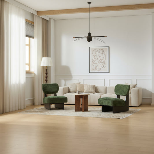 Two green chairs and a wooden table in a room with white walls and a lamp.