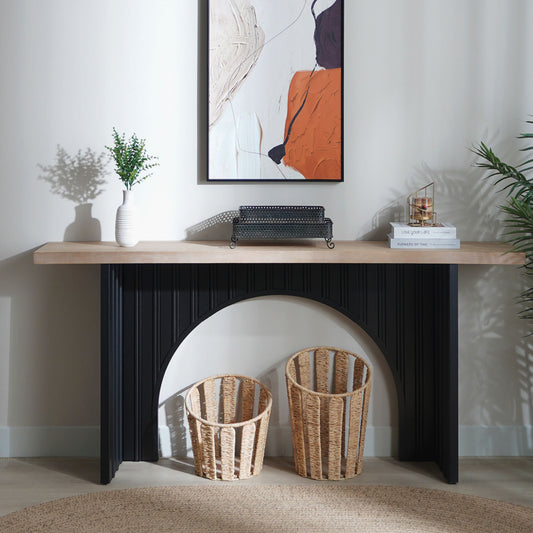 Wooden console table with decorative items against a white wall with abstract art.