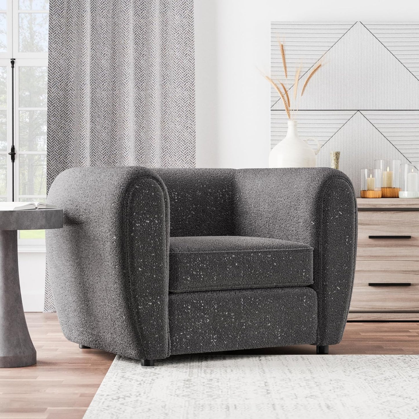 Gray armchair in a living room setting with curtains and a mirror.